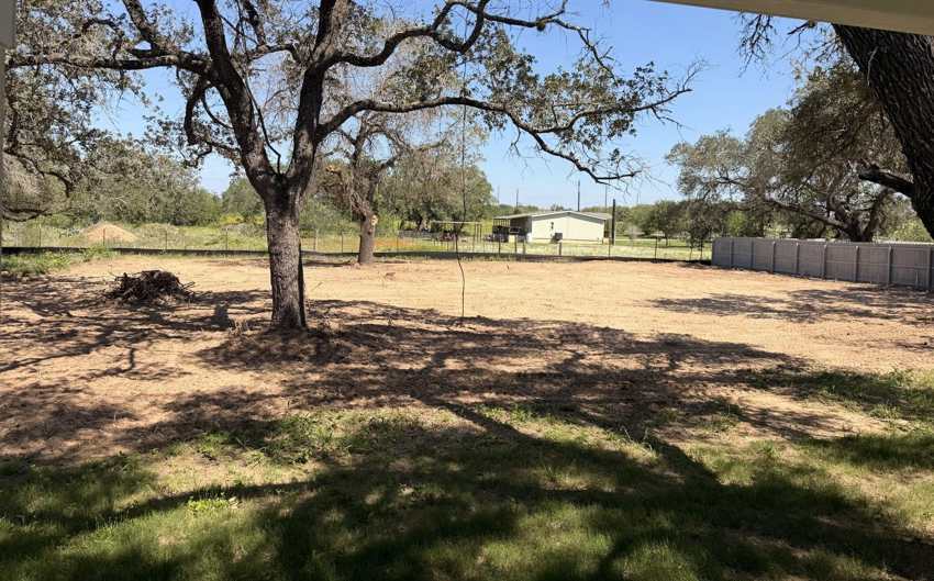 Cleared and leveled dirt lot with mature trees kept